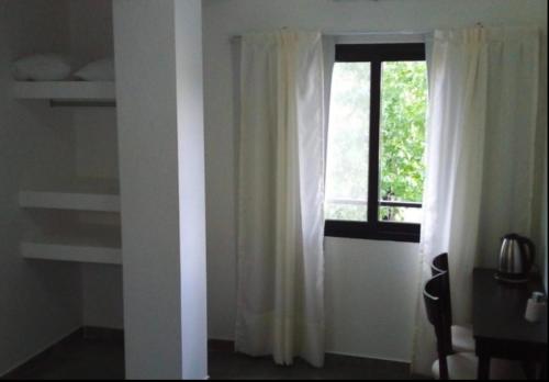 a room with a window with white curtains at BY DANIELS in Federación