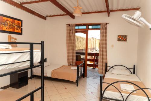 1 dormitorio con 2 literas y balcón en Hotel Luna Nueva, en Colán