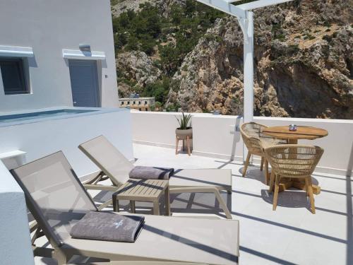 a patio with chairs and a table on a roof at Agnantema luxury suites in Karpathos Town