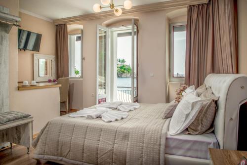 una camera con un grande letto in una stanza con finestre di Oniro PargaTown Luxury Suites a Párga