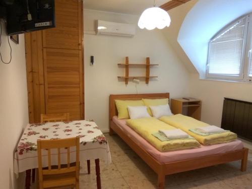 a bedroom with a bed and a table and chairs at Lívia Apartman in Balatonfüred