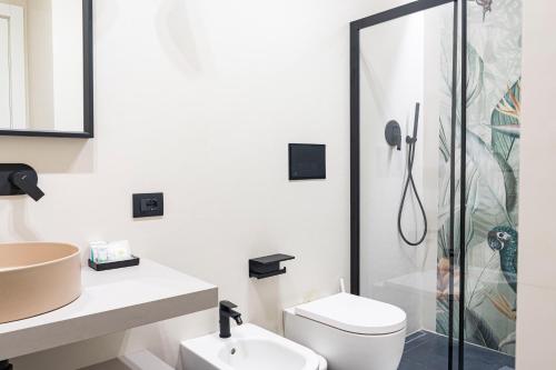 a bathroom with a shower and a toilet and a sink at Ammare rooms in Agrigento