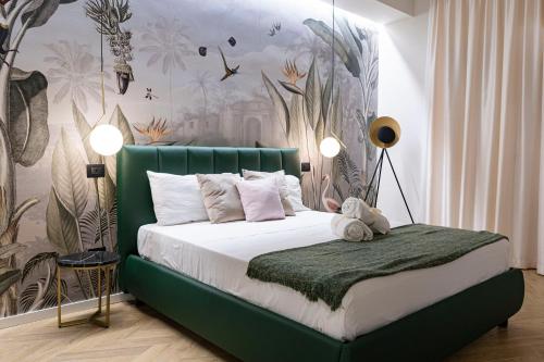 a bedroom with a bed with a green headboard at Ammare rooms in Agrigento