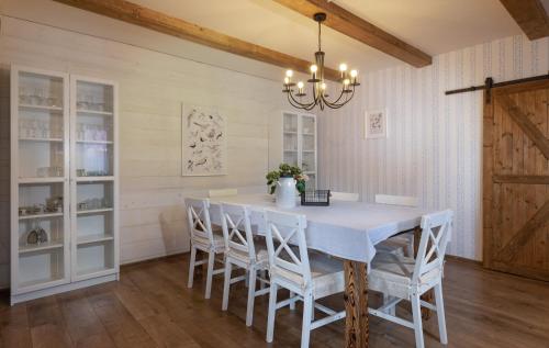 a dining room with a white table and chairs at Wellness Chata Chmaroška - Telgárt Resort in Telgárt