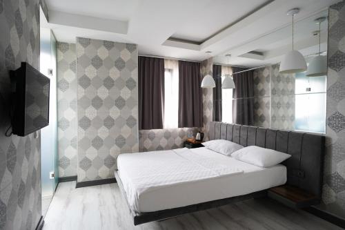 a bedroom with a white bed and a television at Time Hotel Mecidiyekoy in Istanbul