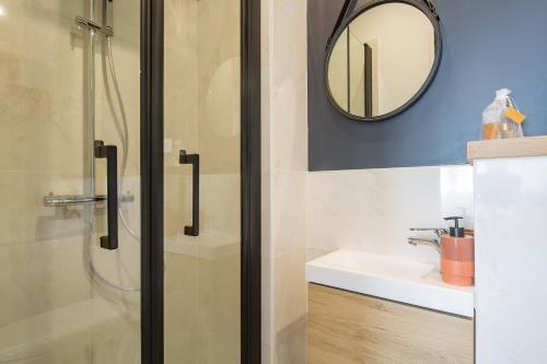 uma casa de banho com um chuveiro, um lavatório e um espelho. em Les Studios du Parc Bordelais - Le Canelé em Le Bouscat