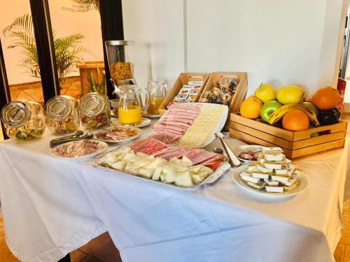a table with a buffet of food and fruit at Hostal Rural Santa Habitaciones Aldea del Rocío in El Rocío
