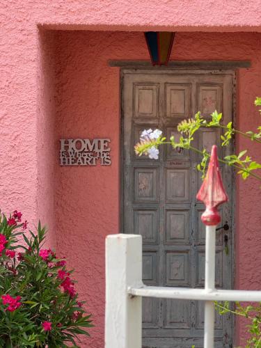 un edificio rosa con una puerta y flores delante en Villa Rosa, en Giustenice