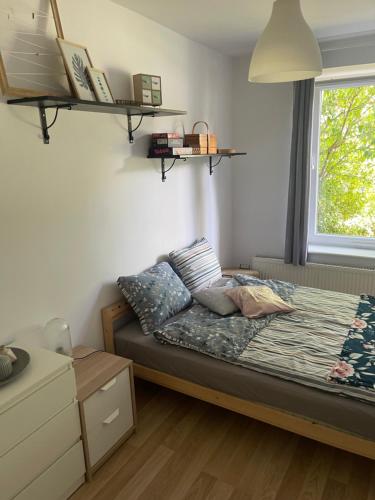 sypialnia z łóżkiem i półkami na ścianie w obiekcie Apartament Słoneczna Oliwa w Gdańsku