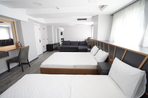 a hotel room with two beds and a couch at Time Hotel Mecidiyekoy in Istanbul