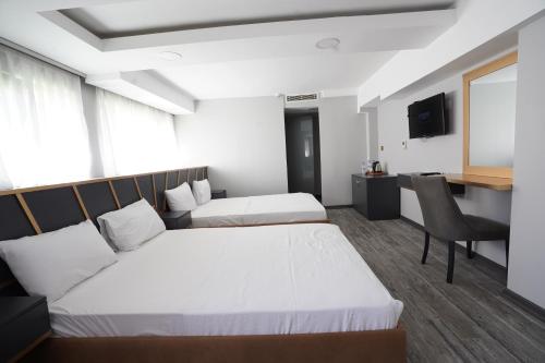 a hotel room with two beds and a desk at Time Hotel Mecidiyekoy in Istanbul