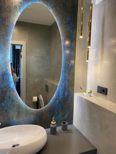 ワルシャワにあるApartament Rzekotka Zielona Dereniowa 60のバスルーム(洗面台の上に円形の鏡付)