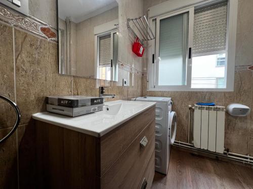 a small bathroom with a sink and a washing machine at Castiñeiras Street in Sarria