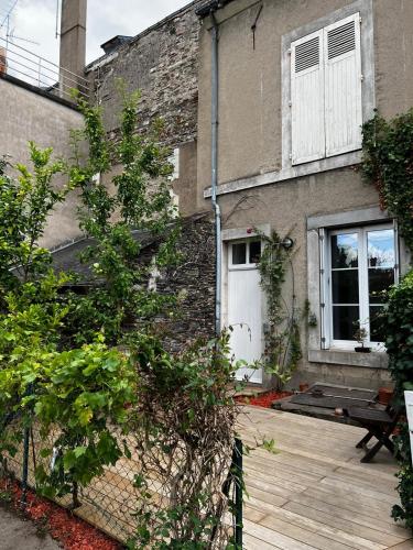 - un bâtiment avec une porte blanche et une terrasse en bois dans l'établissement Charmant studio au calme terrasse privée place de parking sécurisée, à Angers