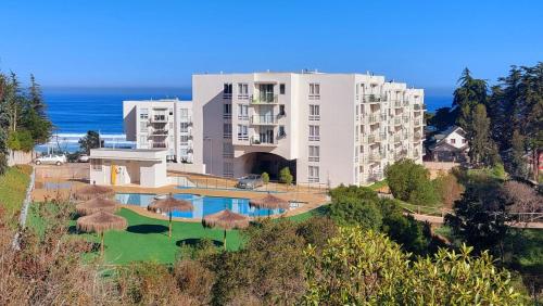 an apartment building with a swimming pool and a resort at Acogedor Departamento en El Tabo in El Tabo