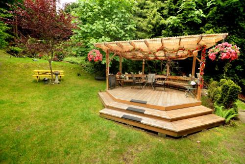 a wooden deck with a gazebo in a yard at Casa Grande Inn in Qualicum Beach