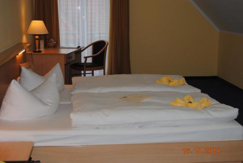 ein Bett mit weißer Bettwäsche und gelben Blumen darauf in der Unterkunft Hotel Stadt Spremberg in Spremberg