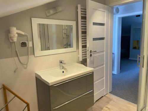 a bathroom with a sink and a mirror at Apartamenty i Pokoje Atlantic in Jastrzębia Góra