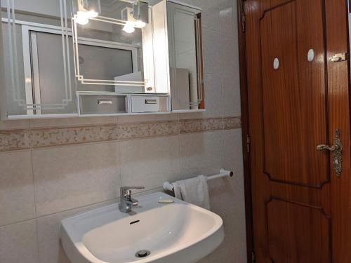 a bathroom with a sink and a mirror at Lá em Cima in Sesimbra