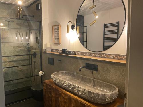 a bathroom with a large stone sink and a mirror at zu Jeddelohs Lodge Hotel in Gladenbach