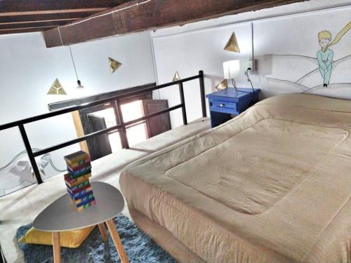 Un dormitorio con una cama y una mesa con libros. en Original y Cómodo Loft en el Centro de Tulancingo, en Tulancingo