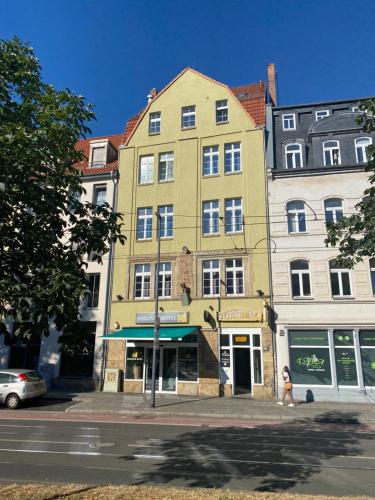 een hoog geel gebouw in een stadsstraat bij Bärliner Hotel in Erfurt