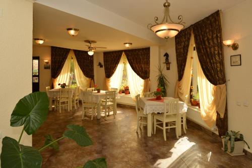 a dining room with white tables and chairs and windows at Bucuria Muntelui in Bran