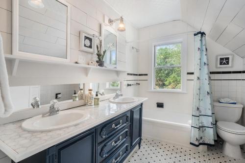 a bathroom with two sinks and a tub and a toilet at The Wayfarer in South Haven