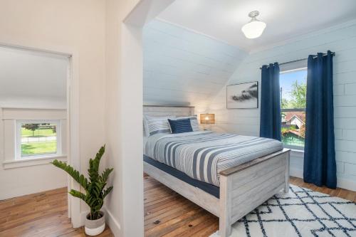 a bedroom with a bed with blue curtains at The Wayfarer in South Haven