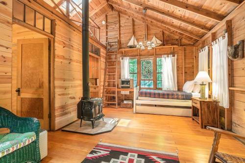 uma sala de estar em chalé de madeira com um fogão a lenha em Deer Creek Cabin em Holland