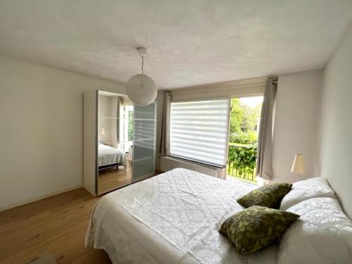 a bedroom with a large bed and a large window at HolidayHome Zonnestraal 9p Amsterdam and the beach in Heerhugowaard