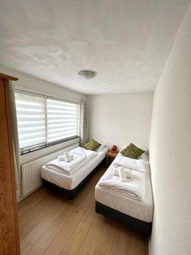 a small room with two beds and a window at HolidayHome Zonnestraal 9p Amsterdam and the beach in Heerhugowaard