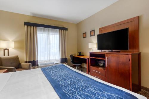 a hotel room with a bed and a flat screen tv at Comfort Inn & Suites Woods Cross - Salt Lake City North in Woods Cross