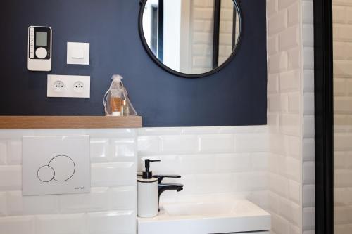 a bathroom with a sink and a mirror at Les Studios du Parc Bordelais - Le Sommelier in Le Bouscat