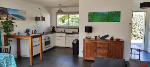 une cuisine avec des armoires blanches et une table en bois dans l'établissement Maison Bassin d'Arcachon, à Gujan-Mestras