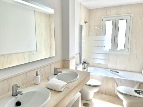 ミハス・コスタにあるMI CAPRICHO 170 Beachfront Apartmentのバスルーム(洗面台2台、トイレ、鏡付)