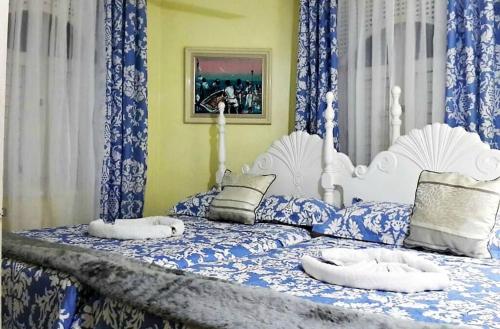 a blue and white bed with two pillows on it at Private 2 Bedroom Beachfront Penthouse Condo Ocho Rios, Jamaica in Ocho Rios