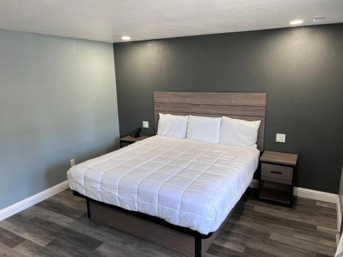 a bedroom with a large bed with white sheets at Surf City Inn & Suites in Santa Cruz