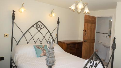 una camera con letto bianco e nero e un bagno di Shepherd's Watch Cottage - 5* Cyfie Farm with private hot tub a Llanfyllin