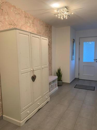 a room with a large white cabinet and a door at Ferienwohnung Schwalbennest in Weinsheim