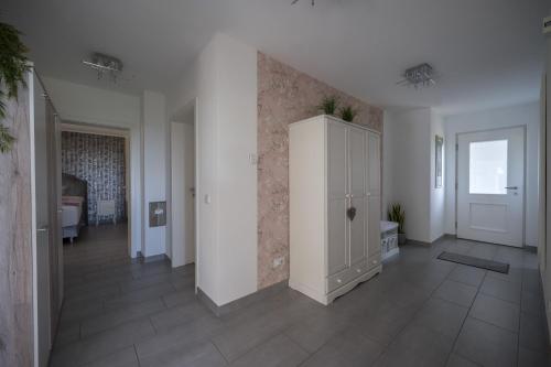 a large room with a white cabinet and a bedroom at Ferienwohnung Schwalbennest in Weinsheim