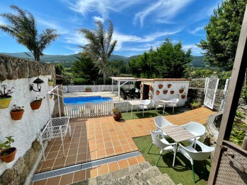 een patio met een tafel en stoelen en een zwembad bij LAR DE SUSA in Pontevedra