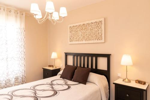 a bedroom with a large bed and two night stands at La casa de San Martín. Parque Warner, Madrid in San Martín de la Vega
