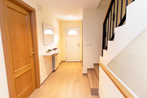 an empty hallway with a door and a stairway at La casa de San Martín. Parque Warner, Madrid in San Martín de la Vega