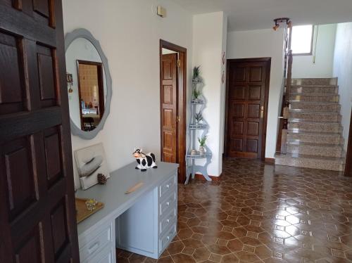 łazienka z umywalką, lustrem i schodami w obiekcie Villa Rica House w mieście Negreira