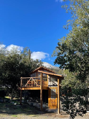 a tree house with a deck in the woods at Cabañas La Calchona in Melocotón
