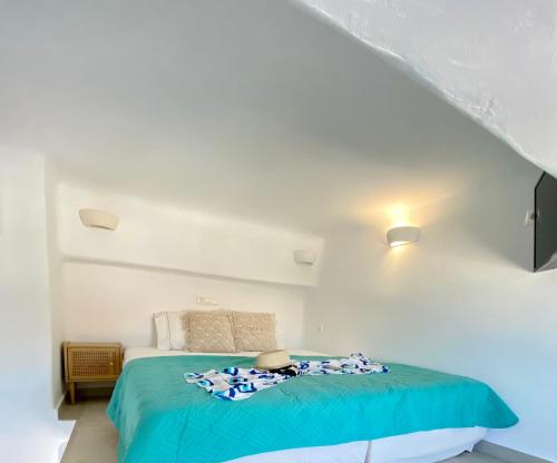a bedroom with a bed in a white room at Gerani Deluxe Houses in Astypalaia Town