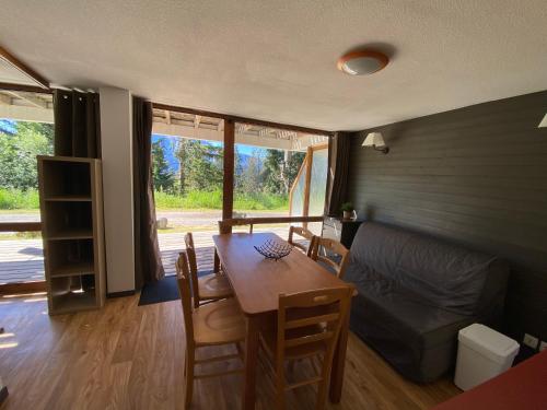 un salon avec une table et un canapé dans l'établissement Au pays des marmottes Appartement 6 personnes plein sud sans vis à vis avec terrasse, à Chamrousse