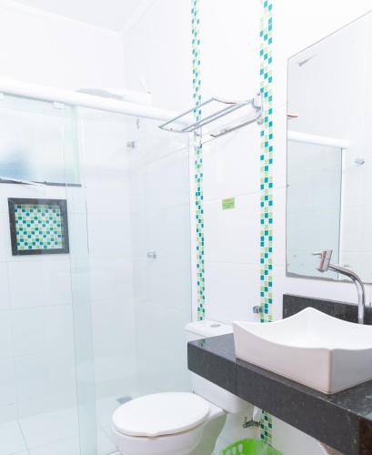 a bathroom with a white toilet and a sink at Pousada Valle Verde in Cabo Frio