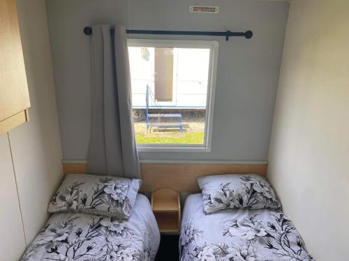 a small room with two beds and a window at Legacy on Highfields in Skegness